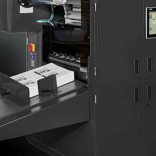 Digital Embellishment Solution from KURZ with open compartment, processing stacked printed sheets labeled "VIP".