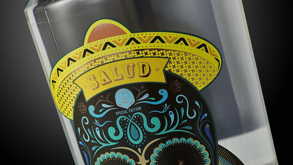 Buntes Flaschenetikett „SALUD Special Edition“ mit Totenkopf Nahaufnahme eines bunten Flaschenetiketts mit Totenkopf im gelben Sombrero und der Aufschrift „SALUD Special Edition“.