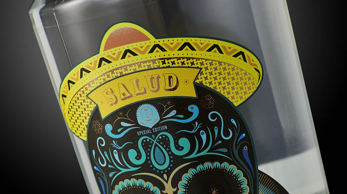 Nahaufnahme eines bunten Etiketts auf einer Flasche, auf dem ein Totenkopf mit einem gelben Sombrero und den Schriftzügen „SALUD” und „Special Edition” zu sehen ist.