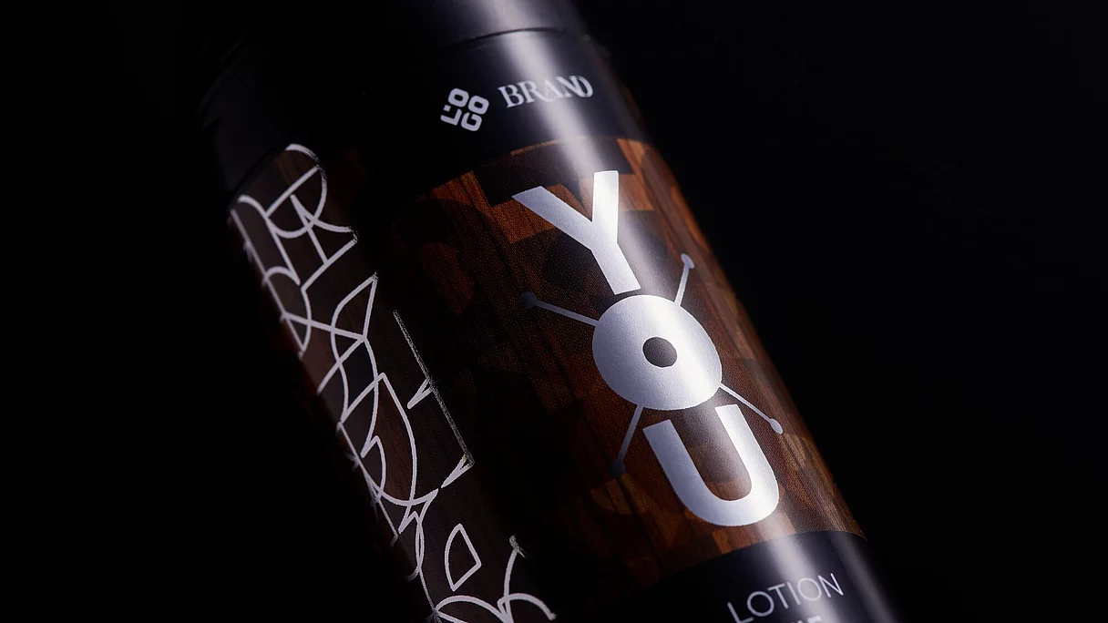 Close-up of a black cosmetic bottle with a decorative brown and white label reading "YOU LOTION #5." 