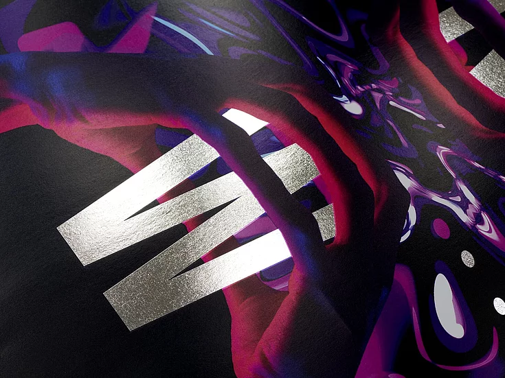 Close-up of a dark, glossy surface with bold silver letters spelling ‘WIN’ and abstract colorful patterns in red and purple.