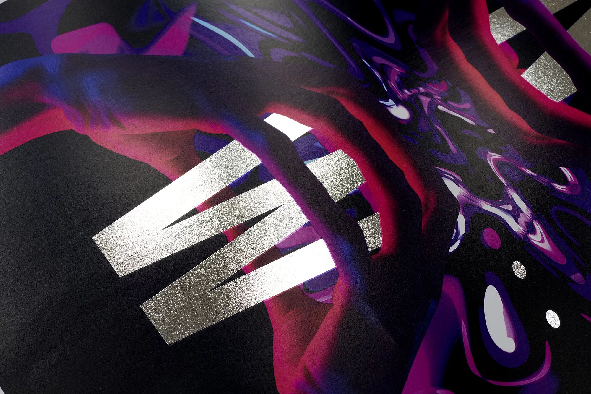 Close-up of a dark, glossy surface with bold silver letters spelling ‘WIN’ and abstract colorful patterns in red and purple.
