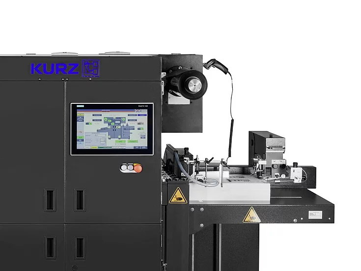 black Kurz machine with touchscreen control panel, used for industrial printing or finishing processes, isolated on white background.