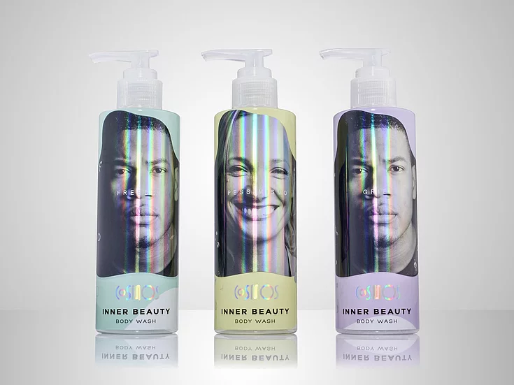 Three “Inner Beauty” body wash bottles with holographic foil labels featuring diverse faces and emotional words, combining minimalistic design with premium print finishing.