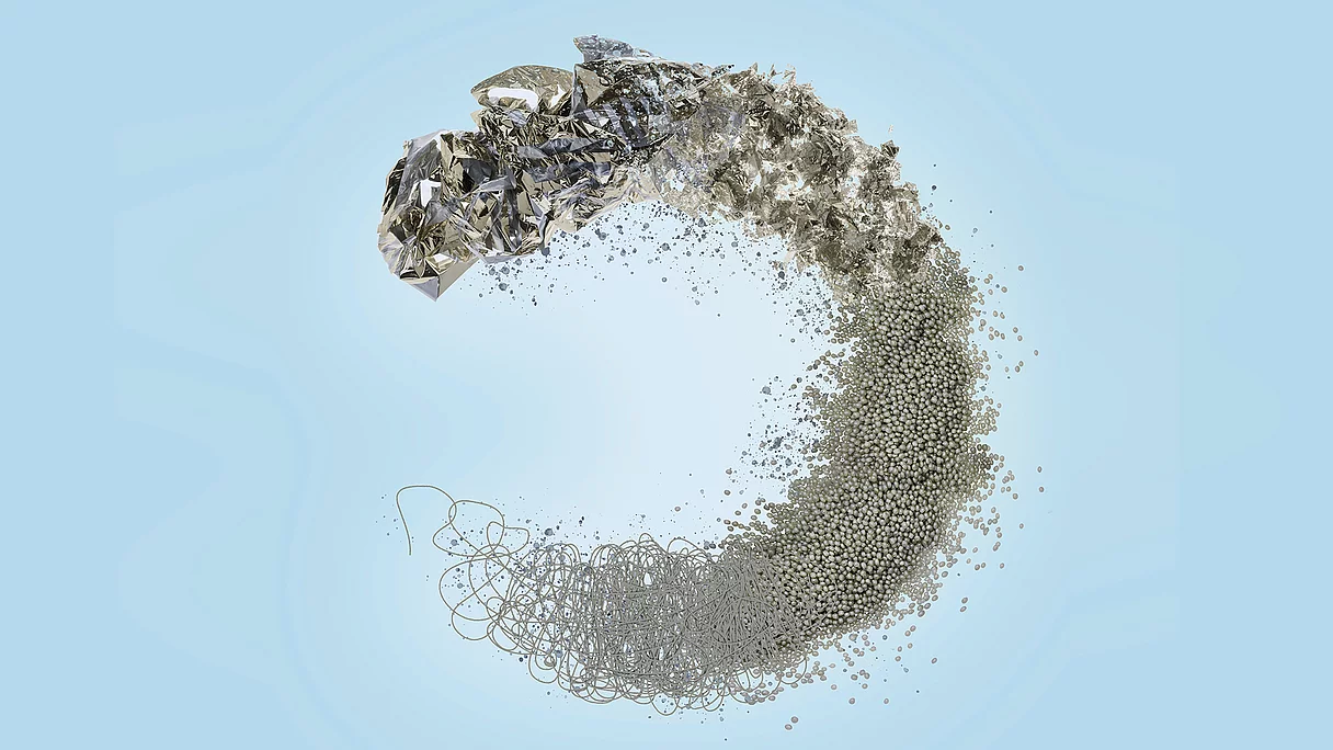Abstract circular symbol made from shredded foil, pellets, and fibers on blue background, representing KURZ's foil recycling and sustainability concept.
