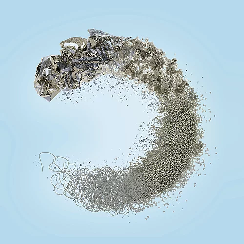 Abstract circular symbol made from shredded foil, pellets, and fibers on blue background, representing KURZ's foil recycling and sustainability concept.