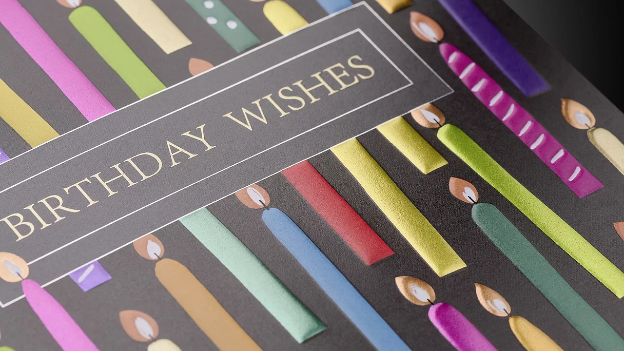 Birthday card with colorful candles and gold-foil "BIRTHDAY WISHES" text.