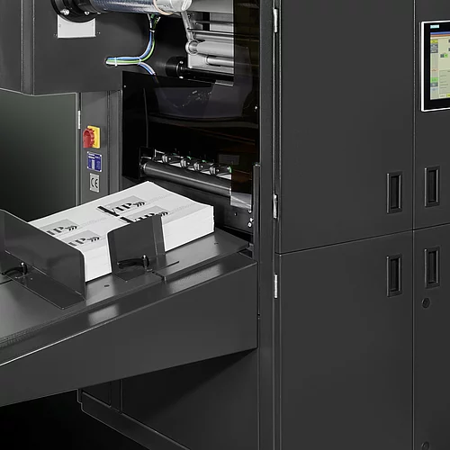 Digital Embellishment Solution from KURZ with open compartment, processing stacked printed sheets labeled "VIP".