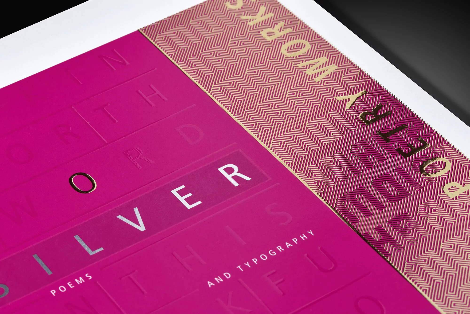 Pink book cover titled “SILVER,” featuring embossed letters and gold foil accents along a patterned border on the right side.