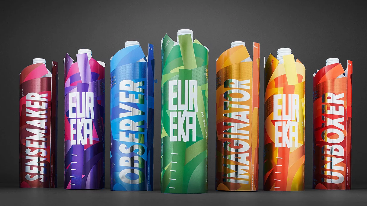 Farbenfrohe Verpackungsröhren im Getränkestil mit auffälliger Typografie und kreativen Namen wie Sensemaker, Observer, Imaginator und Unboxer, die die fortschrittlichen Druck- und Veredelungstechniken von KURZ präsentieren.