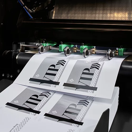 Digital Embellishment Solution from KURZ with open compartment, processing stacked printed sheets labeled "VIP".