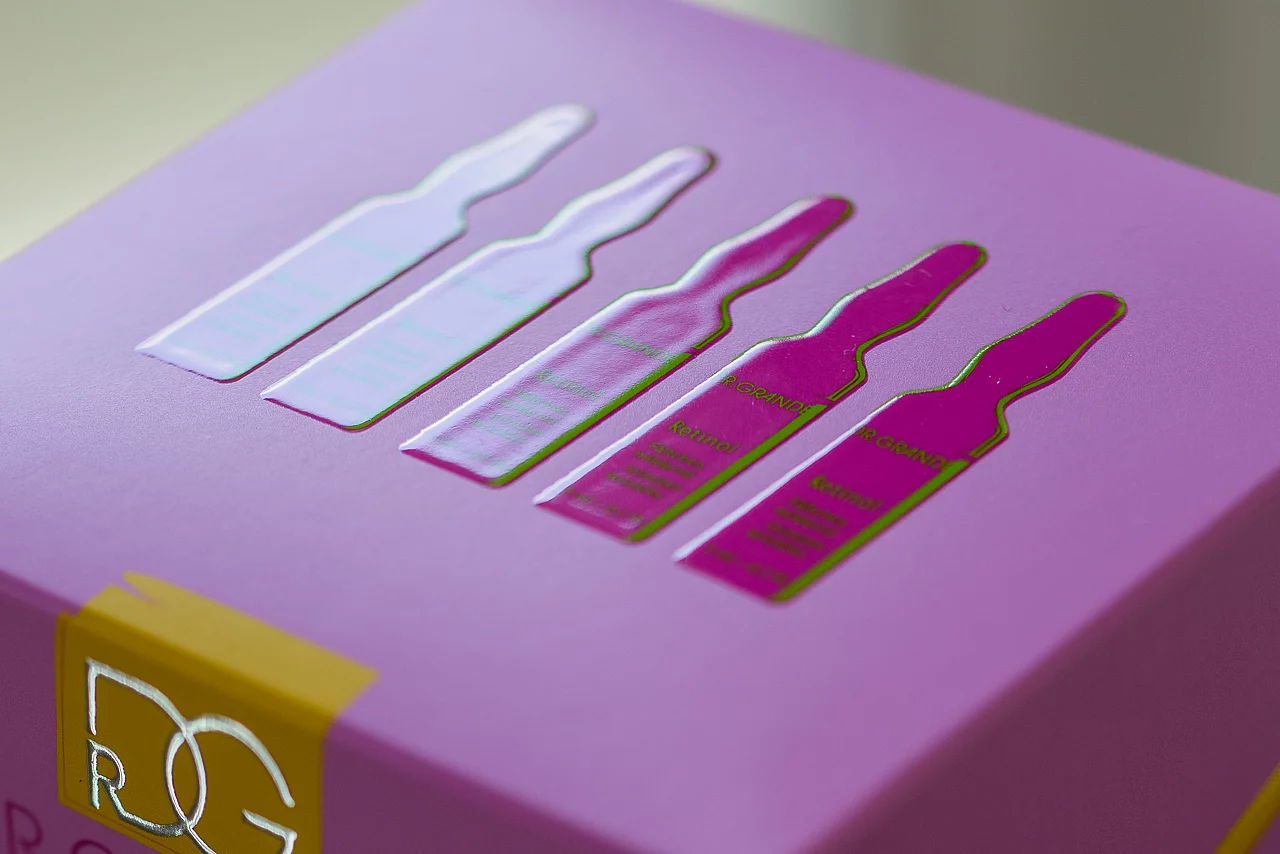 Close-up of a purple product box featuring a raised, glossy design of five ampoules
