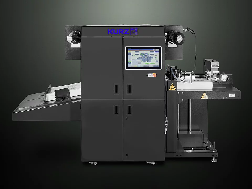 Digital Embellishment Solution from KURZ with open compartment, processing stacked printed sheets labeled "VIP".