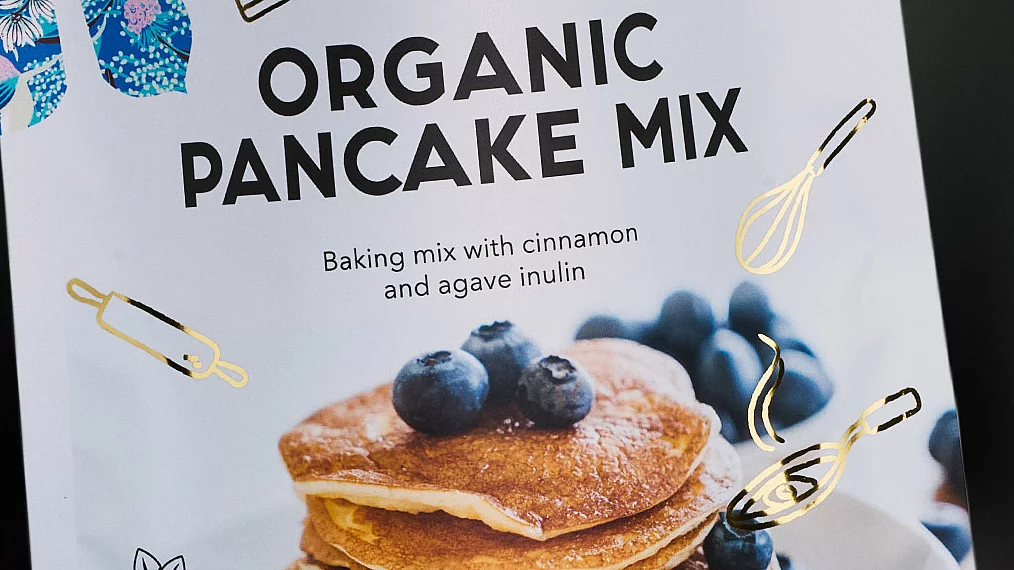 Organic pancake mix package with blueberries, gold foil baking icons, vegan and gluten-free labels, and KURZ logo.