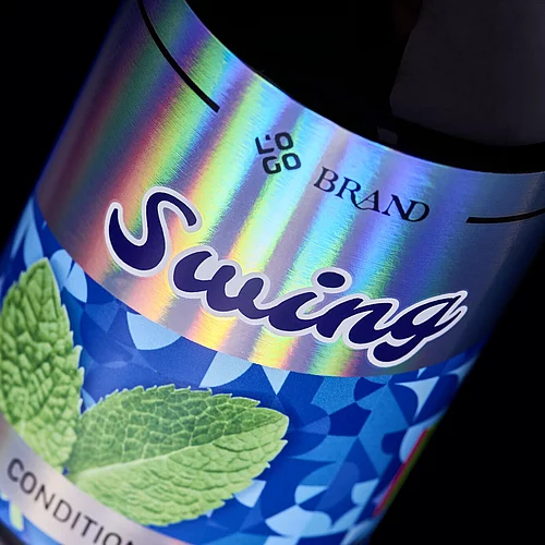 Nahaufnahme eines Etiketts für eine „Swing“-Conditionerflasche mit lebendigen Hologrammfolieneffekten und Minzblattmotiven, das eine hochwertige digitale Veredelung zeigt.
