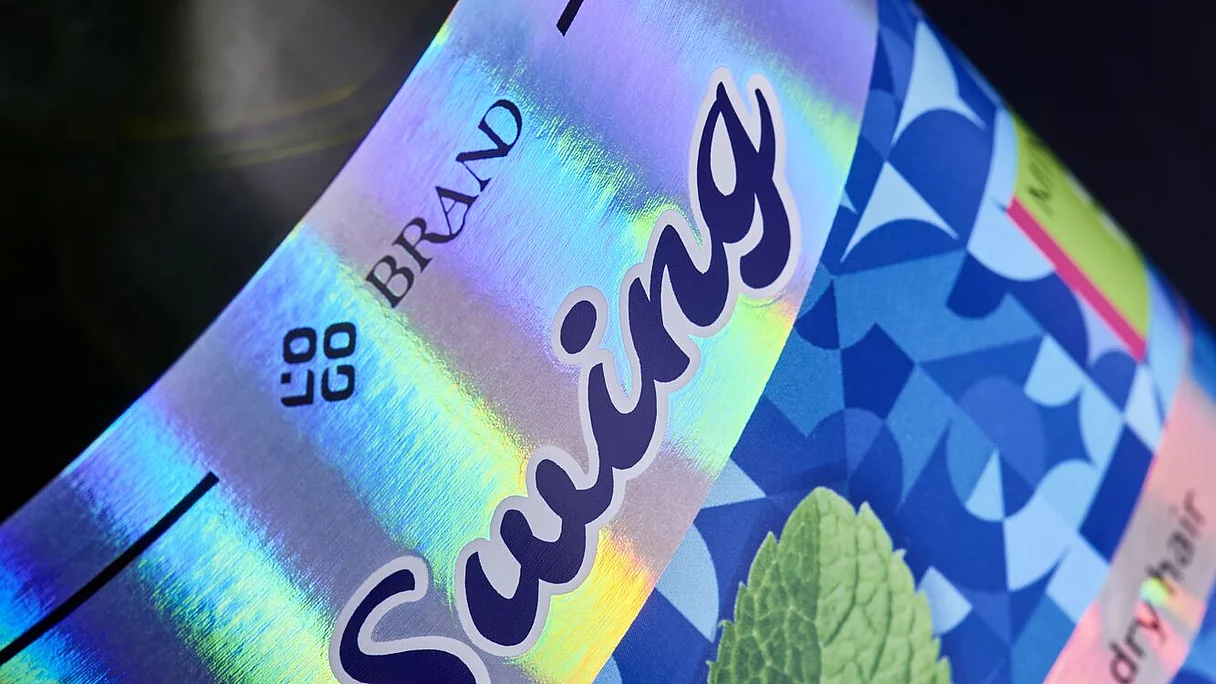 Close-up of a “Swing” conditioner bottle label with vibrant holographic foil effects and mint leaf imagery, showcasing premium digital embellishment