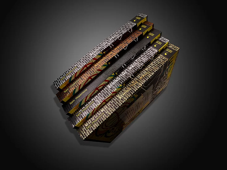 Stack of premium “Behind the Wall” book editions by Sam Hopemore with metallic foil details, textured covers, and vibrant spine designs, showcasing advanced print finishing.