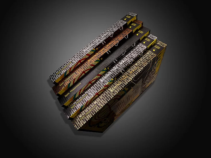 Stack of premium “Behind the Wall” book editions by Sam Hopemore with metallic foil details, textured covers, and vibrant spine designs, showcasing advanced print finishing.