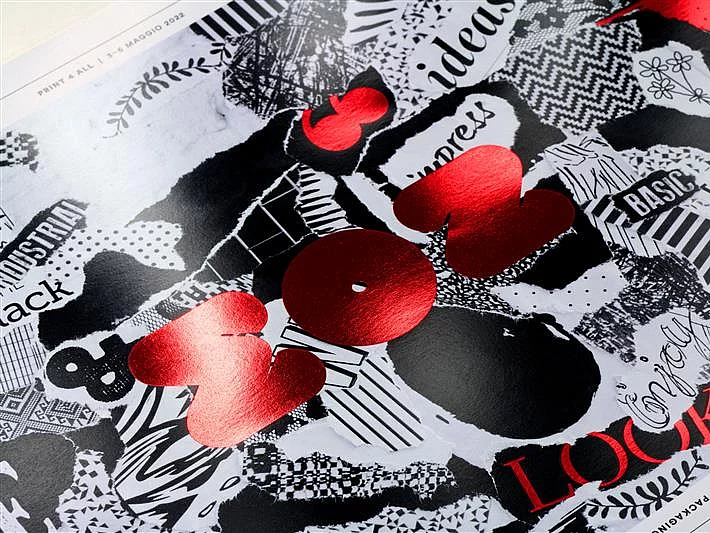 Close-up of a collage-style print with mixed black and white patterns and bold red foil text "2023" and "LOCK!"