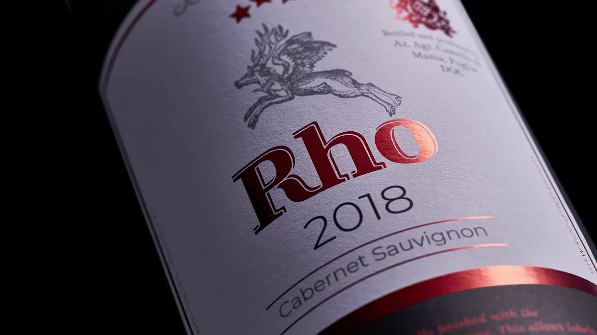 Close-up of a wine bottle label reading "Rho 2018 Cabernet Sauvignon" with red foil detailing.