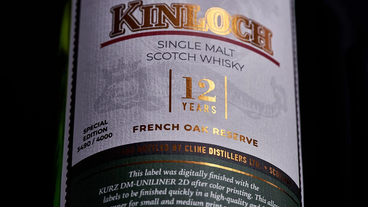 Close-up of a whisky bottle label reading "Kinloch Single Malt Scotch Whisky 12 Years French Oak Reserve" with metallic gold detailing.