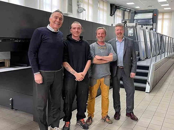 Four people standing next to one another and smiling