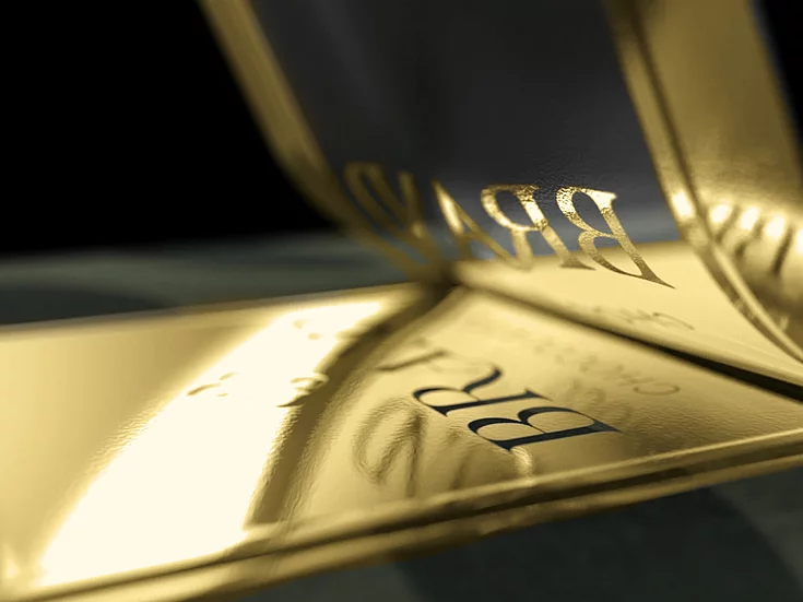 Close-up of glossy gold foil being applied to premium packaging surface using KURZ digital embellishment technology.